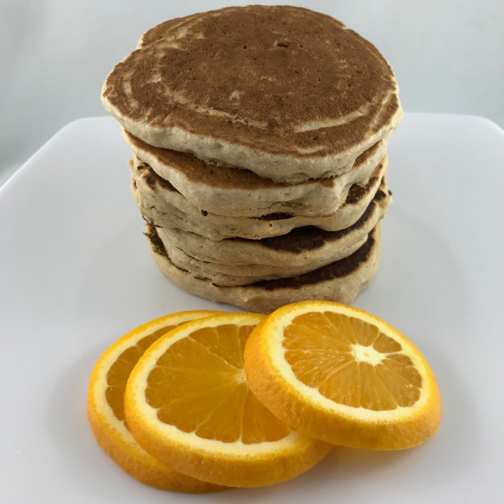 stack of pancakes with orange slices